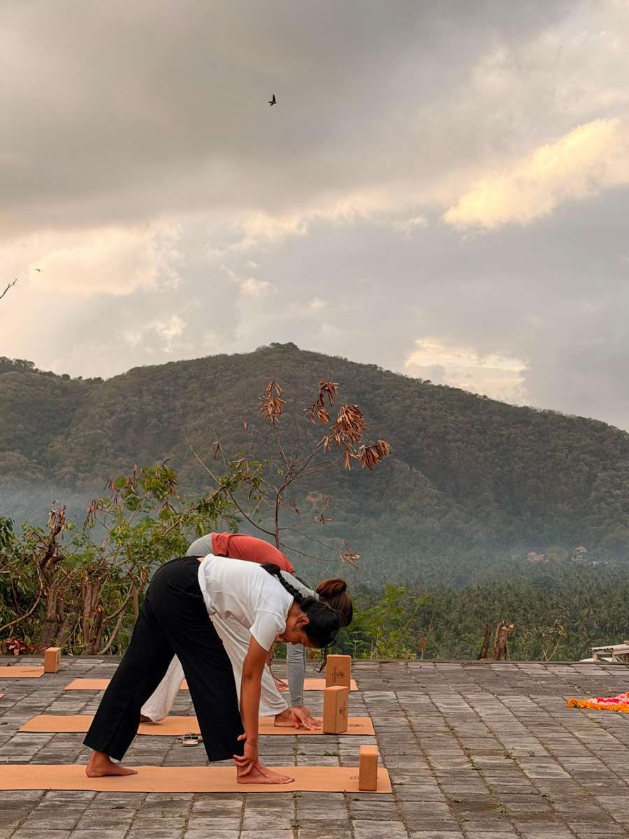 Ubud'da pirinç tarlasına bakan ahşap platformda yoga seansı